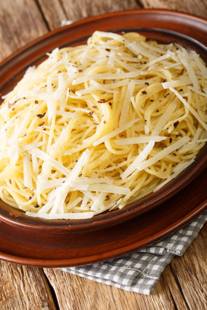 Cacio e pepe Pasta with cheese and pepper closeup in the plate on the table. Vertical