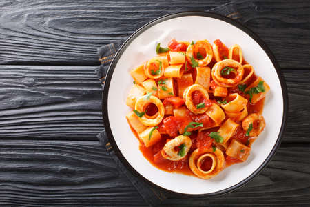 Classic Pasta Calamarata with squid sauce Italian Recipe close-up in a plate on the table. Horizontal top view from aboveの写真素材