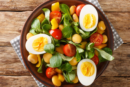 Vitamin delicious salad of lupine beans, boiled eggs, tomatoes and common cornsalad close-up in a plate on the table. horizontal top view from aboveの写真素材