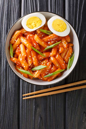 Tteokbokki is one of the most popular Korean street foods in Korea close-up in a bowl on the table. Vertical top view from aboveの写真素材