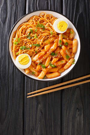 Rabokki is a type of tteokbokki with added ramyeon noodles it is a Korean street food closeup in the bowl on the table. Vertical top view from aboveの写真素材