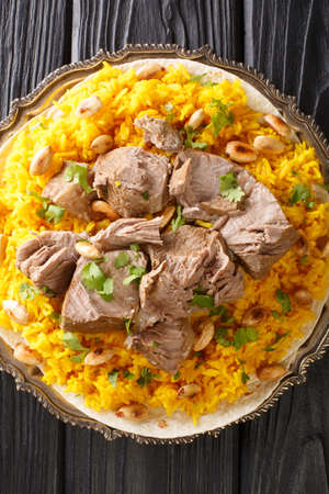 Mansaf is a traditional Arabic lamb dish that is cooked in yogurt sauce with rice closeup in the plate on the table. Vertical top view from aboveの写真素材
