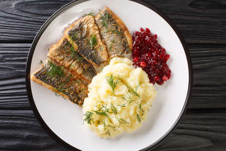 Delicious Fried herring fillet with dill garnished with mashed potatoes and lingonberry sauce close-up in a plate on the table. horizontal top view from aboveの写真素材