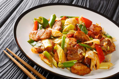 Chinese Spicy Pork Stir Fry Twice Cooked Pork cooked in sauce and vegetables closeup in the plate on the wooden table. Horizontalの写真素材