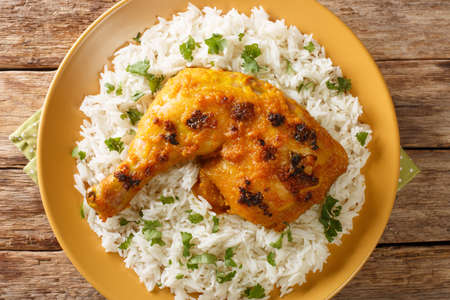 Ayam Percik a Malaysian grilled chicken marinated in flavorful spices served with rice close up in the plate on the table. Horizontal top view from aboveの写真素材
