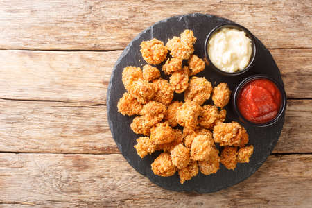 Crispy Chicken Popcorn with Tomato Ketchup and mayonnaise closeup in the slate dish on the table. Horizontal top view from aboveの写真素材