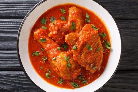 Spicy Tomato Chicken Ayam Masak Merah close-up in a bowl on the table. Horizontal top view from...