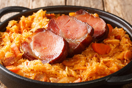 Baked Sauerkraut Podvarak with carrot, onion, smoked pork and bacon closeup in the pan on the table. horizontalの写真素材