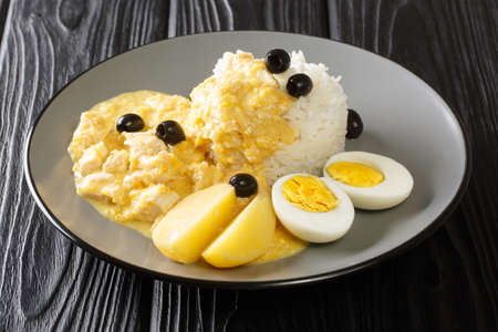 Aji de Gallina in a creamy sauce with parmesan, pepper and onion, served with rice and boiled eggs close-up in a plate on the table. horizontalの写真素材