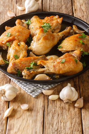 Pollo Al Ajillo Classic Spanish Fried Garlic Chicken close-up on a plate on the table. Verticalの写真素材
