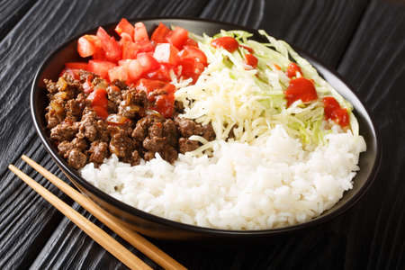 Taco rice takoraisu is a popular example of Okinawan cuisine it consists of taco flavored ground beef served on a bed of rice close-up in a bowl on the table. Horizontalの写真素材