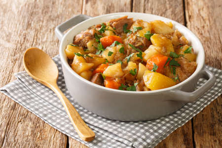 Stovies are a scottish favorite made with potatoes, onions and carrots close up in the pot on the table. Horizontalの写真素材