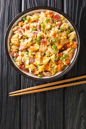 Authentic Yangzhou Fried Rice Chao Fan close up in the plate on the table. Vertical top view from aboveの写真素材