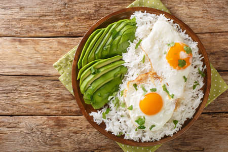 Arroz con huevo frito is white rice and a fried egg close up in the plate on the table. Horizontal top view from aboveの写真素材