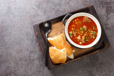 Traditional soup Chorba Frik made from lamb, Freekeh and vegetables close-up in a plate on the table. Horizontal top view from aboveの写真素材