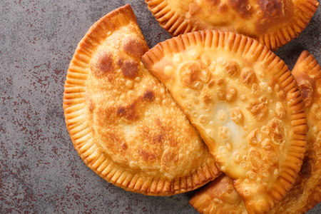 Chebureki is a deep-fried turnover with a filling of ground or minced meat and onions close up in...