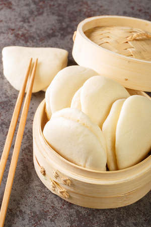 Close up Steamed Bao Buns leaf on bamboo basket on the table. Verticalの写真素材