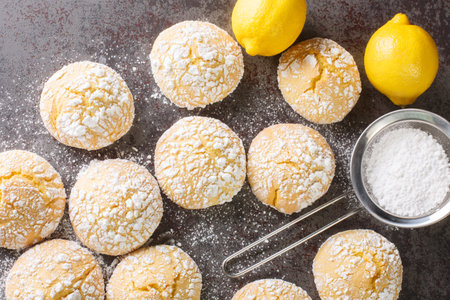 Homemade cracked lemon cookies with powdered sugar and zest close-up on the table. horizontal top view from aboveの写真素材