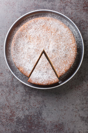 Homemade yogurt cake from simple ingredients close-up on a plate on the table. Vertical top view from aboveの写真素材