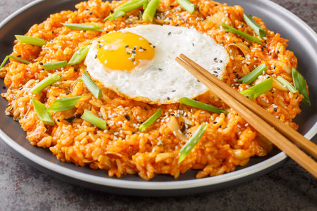 Kimchi fried rice with fried egg on top and chopsticks for eating Korean food closeup on the plate on the table. Horizontalの写真素材
