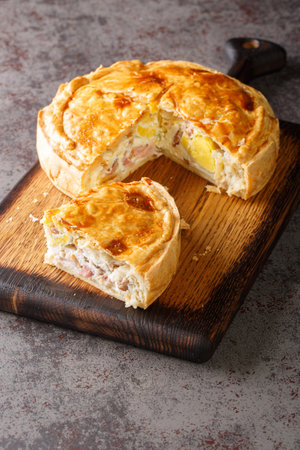 Slice of bacon and egg pie is ready for take away closeup on the wooden board on the table closeup. Verticalの写真素材