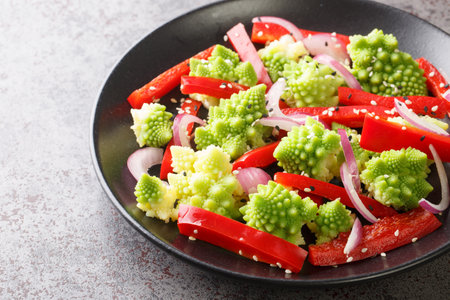 Vegan salad of fresh vegetables and romanesco cabbage close-up in a plate on the table. Horizontalの写真素材