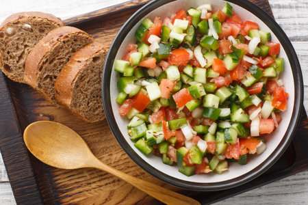 Tasty Pipirrana is a simple Spanish salad from Andalusia with tomatoes, cucumbers, bell peppers and onion closeup on the plate on the table. Horizontal top view from aboveの写真素材