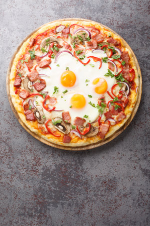 Australian traditional pizza with ham and eggs close-up on a wooden board on the table. Vertical top view from aboveの写真素材