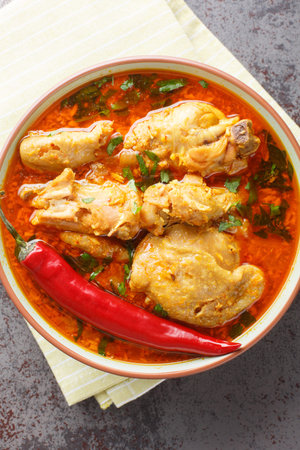 Chicken cooked in spicy gravy made with authentic flavor of malvani closeup on the bowl on the...