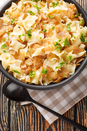 Caramelized Austrian Krautfleckerl Cabbage and Pasta with onion closeup on the bowl on the table. Vertical top view from aboveの写真素材