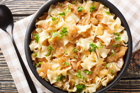Austrian noodles with stewed white cabbage and caramelized onions close-up in a bowl on the table. Horizontal top view from aboveの写真素材