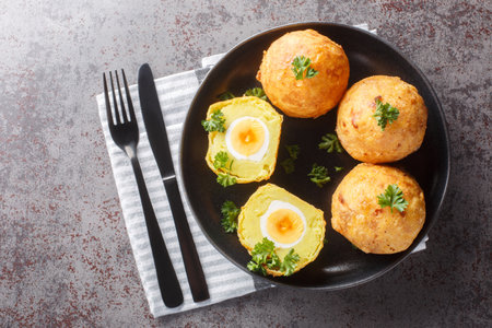 Guyanese cassava balls stuffed with boiled egg and then fried close up in a plate on the table. Horizontal top view from aboveの写真素材