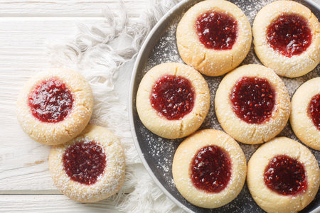 Thumbprint or Hallongrottor Swedish Raspberry Jam Cookies closeup on the plate on the white wooden table. Horizontal top view from aboveの写真素材
