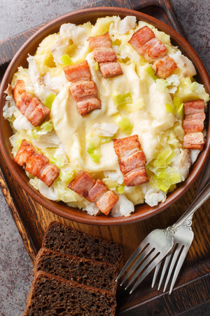 Norwegian Spring Cod Plukkfisk with boiled potato, leek, bacon and bechamel sauce close up on a plate on the table. Vertical top view from aboveの写真素材