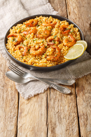 Healthy seafood dish Risotto with shrimp, lemon and fresh herbs closeup on the plate on the wooden table. Verticalの写真素材