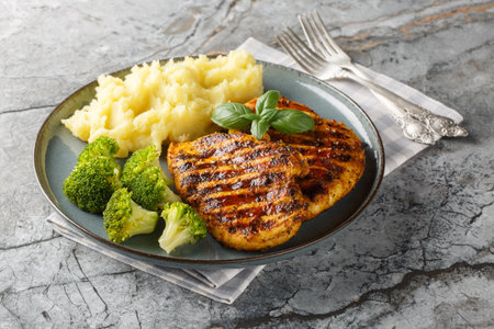 portion of grilled chicken breast with a side dish of mashed potatoes and broccoli close-up in a plate on the table. horizontalの写真素材