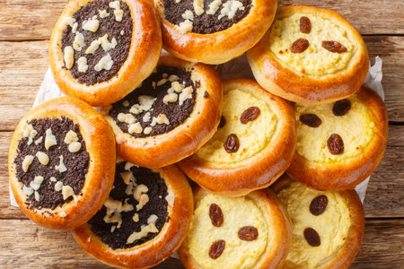 Homemade Czech kolach with traditional filling of cottage cheese with raisins and poppy seeds with streusel close-up on parchment on the table. Horizontal top view from aboveの写真素材