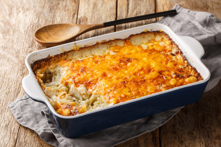 Homemade Cheesy Hashbrown Casserole with Potatoes and Cream closeup in the baking dish on the wooden table. horizontalの写真素材