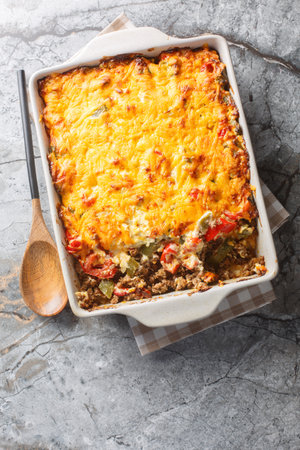 Delicious John Wayne casserole with beef, biscuits, cheese and vegetables close-up in a baking dish on the table. Vertical top view from aboveの写真素材