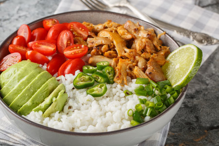 Shredded chicken meat Carnitas with rice, tomatoes, jalapeno pepper and avocado close-up in the bowl on the table. horizontalの写真素材