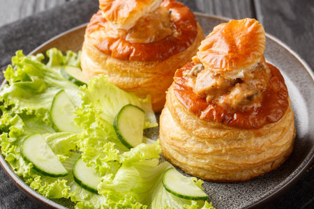 Beef stuffed French vol au vent served with lettuce and cucumber close-up in a plate on a wooden table. horizontalの写真素材