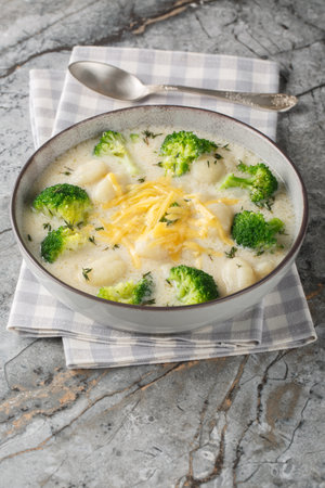 Broccoli and Cheese Soup with Gnocchi closeup on the plate on the table. Verticalの写真素材