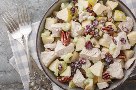 Delicious diet chicken salad with celery, apple, pecan and dried cranberries close-up in a bowl on the table. Horizontal top view from aboveの写真素材
