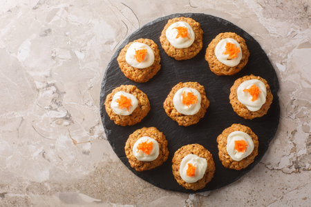 Homemade Carrot oatmeal cookie cake with cream cheese frosting close-up on plate on table....