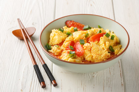 Cantonese Style Tomato Egg Stir-fried with green onion closeup on the plate on the wooden table. horizontalの写真素材