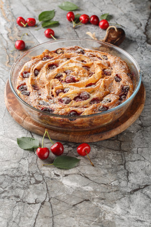 Berry filo pastry pie with cherries and custard close-up in a glass bowl on a wooden board. verticalの写真素材