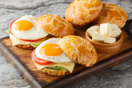 Hong Kong Style Fried Eggs Sandwich with tomato, cheese, lettuce close-up on wooden board on table....