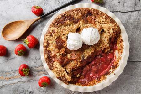 Summer dessert cocoa strawberry cobbler with vanilla ice cream close-up in baking dish on table. horizontal top view from aboveの写真素材