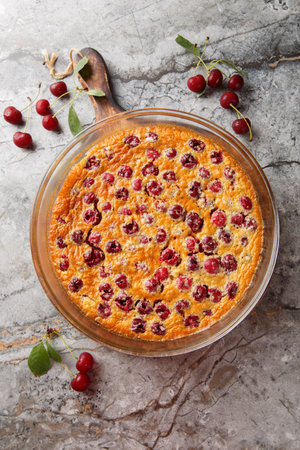 pour-in clafoutis pie with cherries classic French dessert close-up on table. Vertical top view from aboveの写真素材