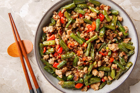 Asian food stir-fried green bean with minced pork closeup in the bowl on the table. Horizontal top view from aboveの写真素材